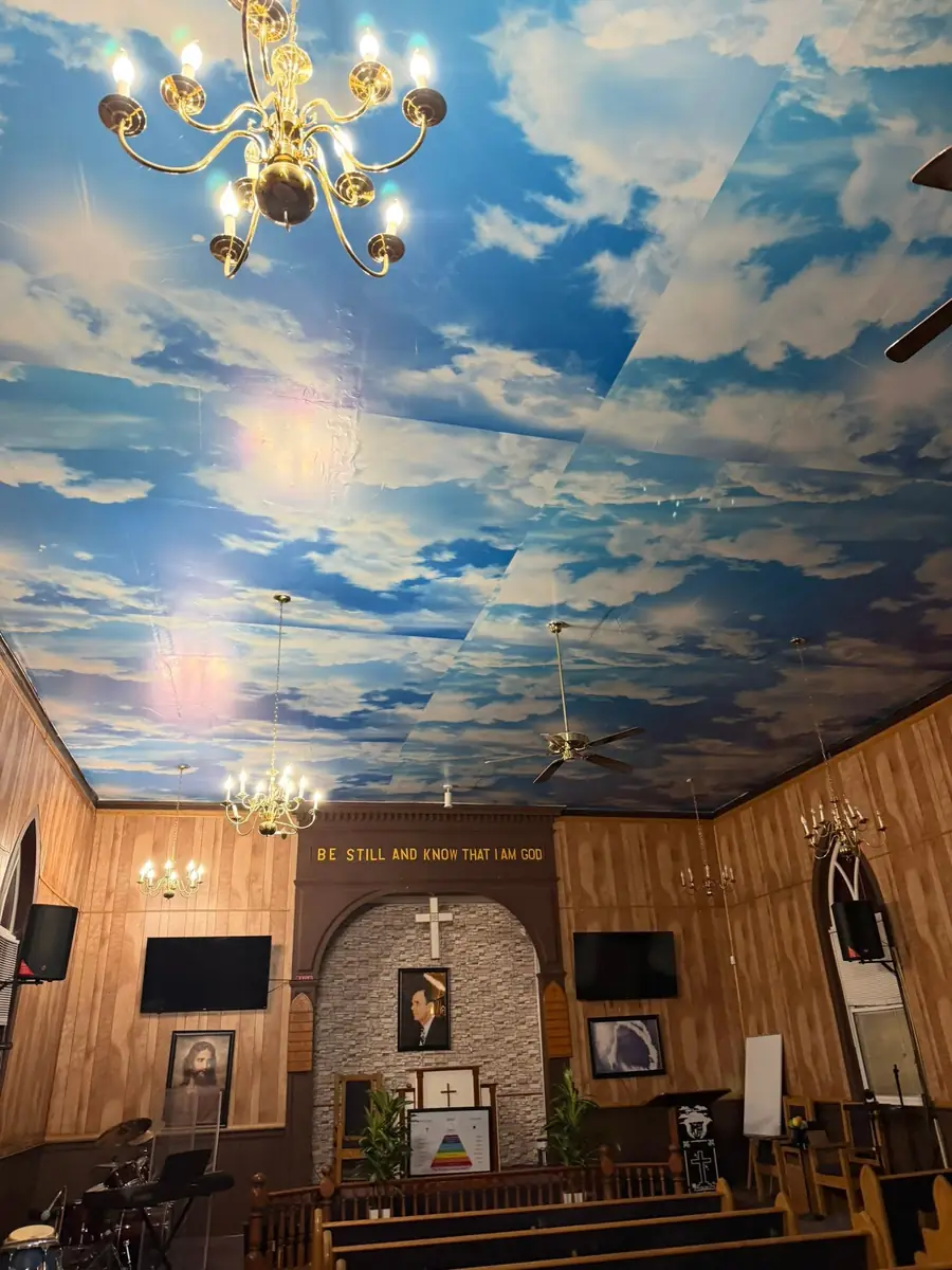 Church ceiling finished with a sky mural, chandeliers and ceiling fans